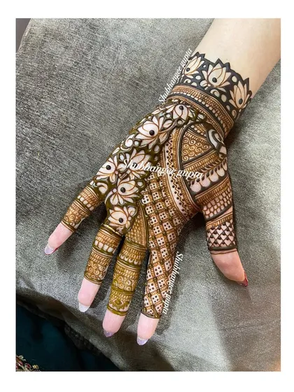 A simple yet elegant design for the back of the hand. The pattern combines lotus flowers with a peacock feather motif for a graceful look.