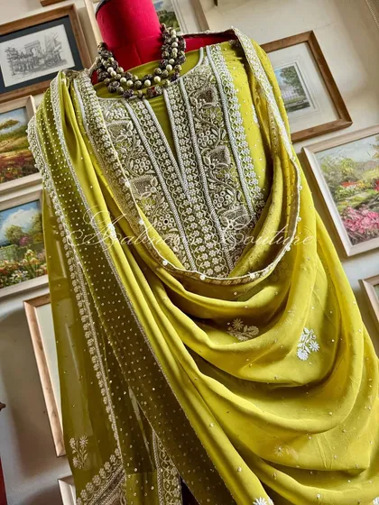 This Mustard Green ensemble, hand-embroidered on pure georgette, is a celebration of rich, earthy tones. The delicate threadwork is complemented by zero-sized embellishments, creating a piece that balances traditional motifs with contemporary color.