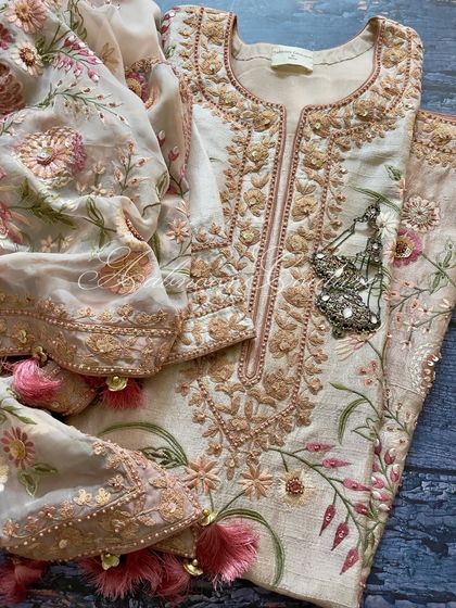 Our ombré dyed salmon pink suit, featuring intricate Doriwork on the neckline and a broad embroidered border on the sleeves. The front panel is adorned with an all-over embellished jaal.