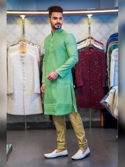 A client, Ayush Khatri, trying on a vibrant green kurta with subtle self-patterning in my store. The color is fresh and perfect for festive occasions.