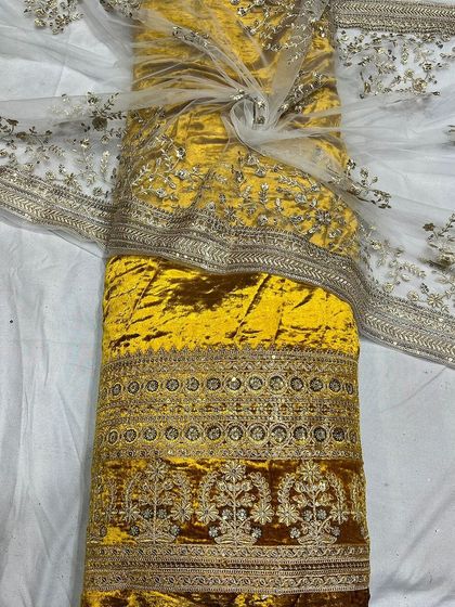 This bright yellow velvet fabric brings a touch of sunshine to the luxurious collection. The detailed embroidery along the border makes it a standout choice for haldi or sangeet ceremonies.