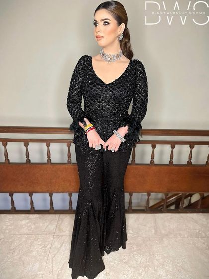 A client in a stunning black sequined outfit with her hair in a sleek, high ponytail. This is a chic and modern look for a cocktail party or reception.