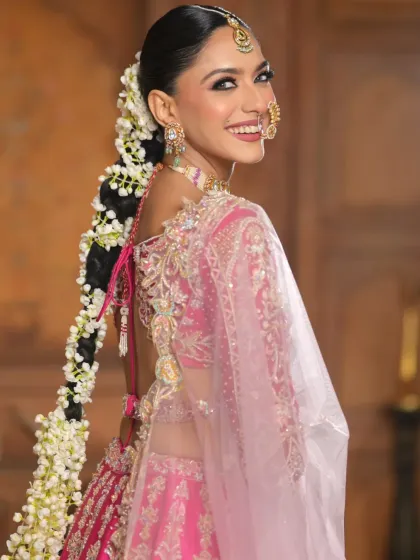 A dynamic shot showing the movement of the long floral braid. This demonstrates how the hairstyle performs on set during a fashion shoot, adding a graceful element to the model's poses.