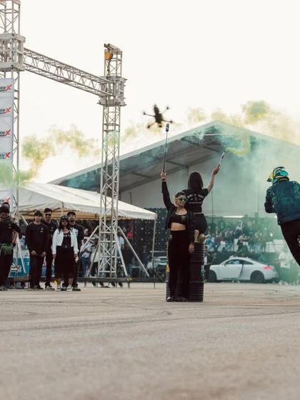 Another angle of the stunt show, capturing a rider mid-wheelie with a drone flying overhead. We use dynamic media coverage to capture every angle of the action.