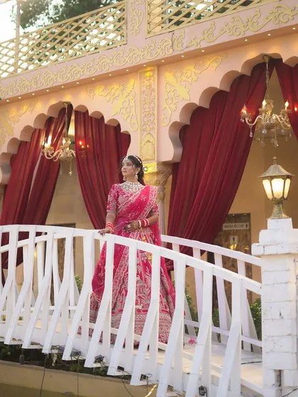 A majestic shot of the bride on a bridge, with the grand wedding decor in the background.