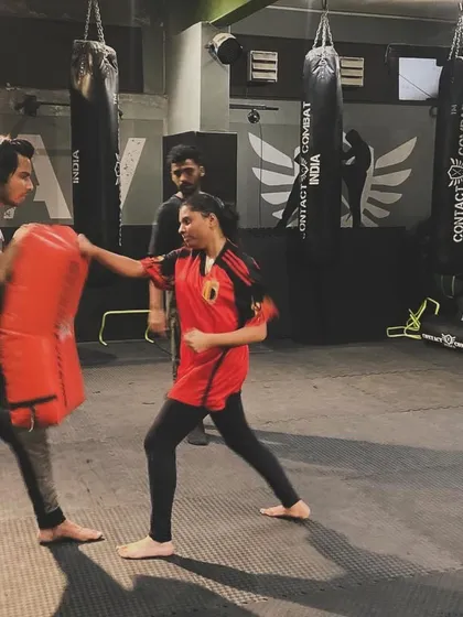 A student practices her straight punch on a kick shield. This fundamental technique, when executed correctly, is one of the most effective tools in self-defense.