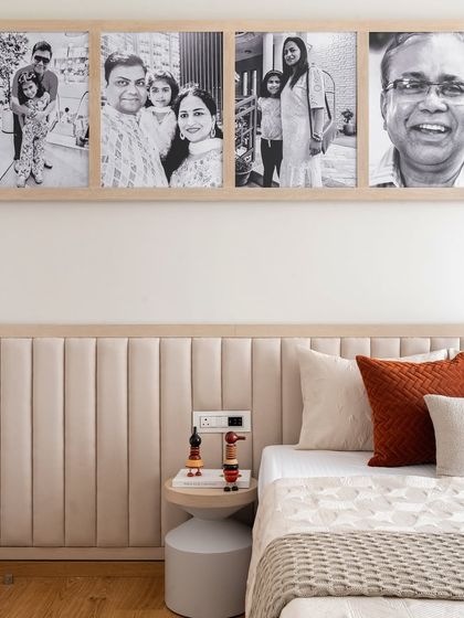 A closer look at the personalized photo collage in this warm and inviting bedroom. The black and white photos add a timeless quality, while the neutral headboard provides a soft, comfortable backdrop.
