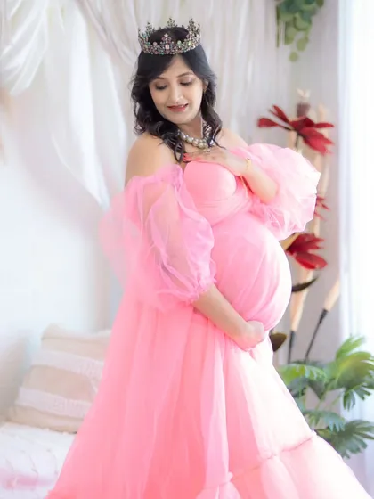 A princess moment. This expecting mother looks radiant in a soft pink off-the-shoulder gown and crown, capturing the gentle and dreamy side of pregnancy.