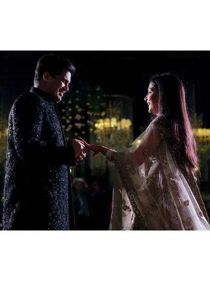 Aayush puts a ring on Saanya's finger during their engagement. The soft light and their happy expressions make this a classic and beautiful ring ceremony shot.