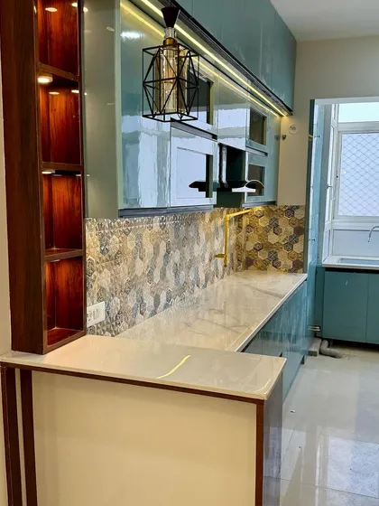 A closer look at the breakfast counter and open-shelf spice rack, finished in a rich wood laminate, which adds warmth to this modern kitchen.