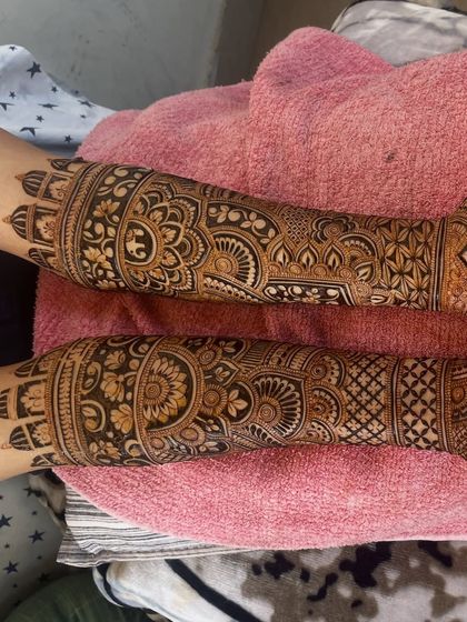 This design features bands of elephant motifs and intricate mandalas, covering the arms completely.