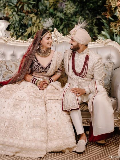 A sweet, candid moment of the couple seated together, sharing a smile and conversation during their reception.