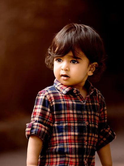 They grow up so fast, don't they? This classic outdoor portrait of a toddler boy in his plaid shirt captures that fleeting innocence perfectly. These are the memories you'll hold onto forever.