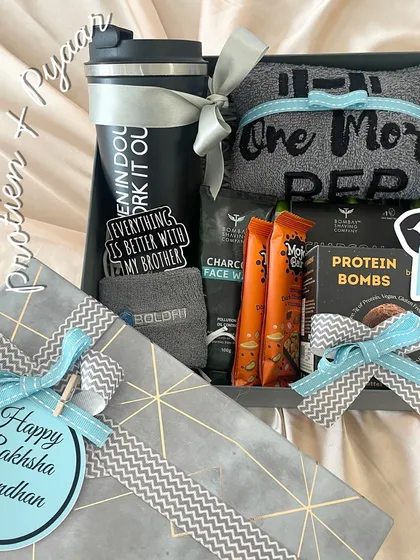 For the brother who is a fitness enthusiast, this 'Protein x Pyaar' hamper is the perfect Rakhi gift. It comes with a gym shaker, a "One More Rep" towel, protein bars, and a charcoal facewash.