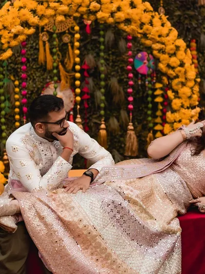 I love capturing the playful side of a couple's love story. Here, during a vibrant Kashmiri 'Saath Mainz' ceremony, the bride playfully teases her groom against a backdrop of marigold decor. It’s these unposed, candid moments that truly show a couple's unique chemistry.