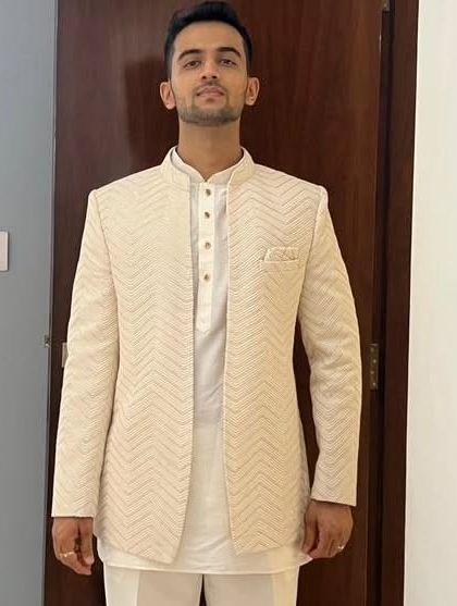 A full-length view of the cream Lakhnavi open Jodhpuri. The clean lines and detailed fabric make it a versatile piece for various pre-wedding functions.