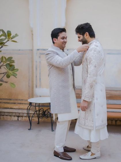 A heartwarming moment as a friend or brother helps the groom get ready, capturing the bond and anticipation before the ceremony.