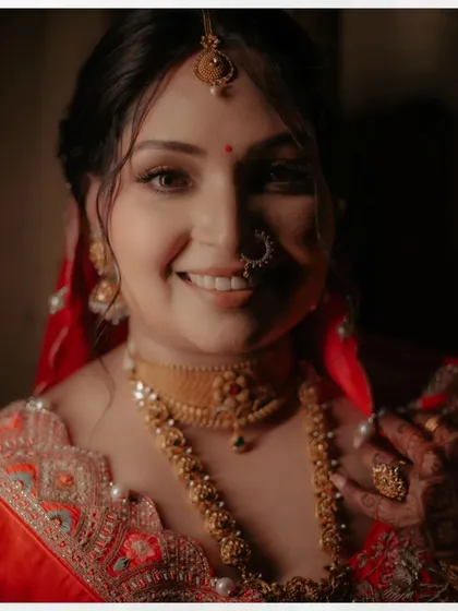 A radiant close-up of Shalini, her happy smile and traditional gold jewelry shining brightly.