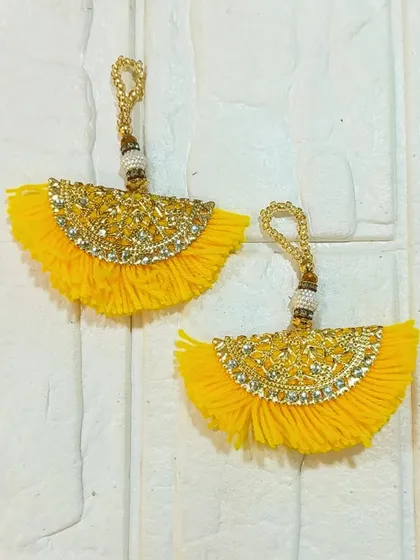 This pair of yellow fan-shaped tassels with gold detailing is a beautiful decorative element for any festive project. They can be used to adorn platters, curtains, or traditional outfits.