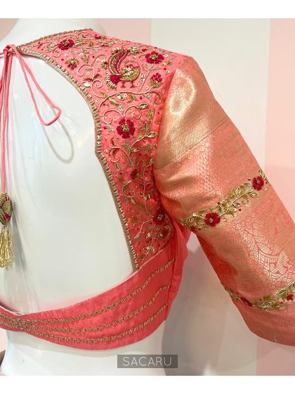 The full back view of a peach Kanjeevaram blouse, showcasing a beautiful embroidered arch design with a decorative tassel tie-up.