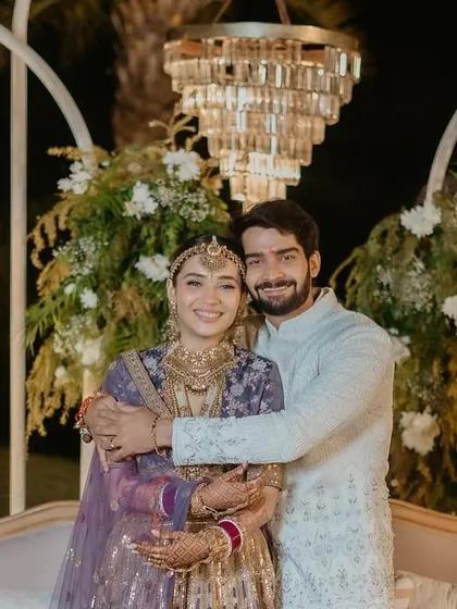 The happy couple at their 'Luxe Garden' reception. The backdrop of lush florals and modern chandeliers created a picture-perfect setting for their celebration.