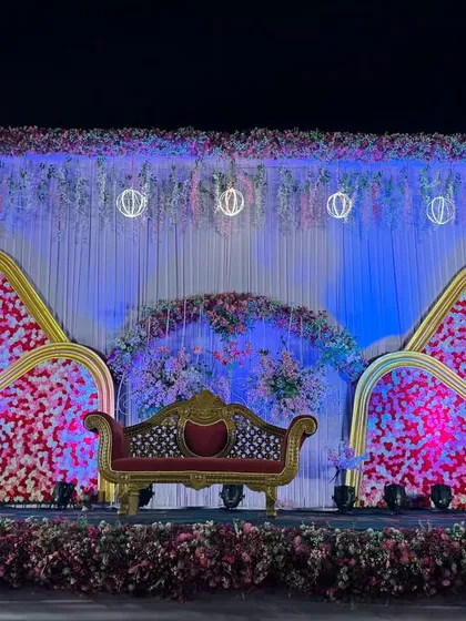A modern wedding stage with a unique, multi-layered backdrop featuring floral panels in red and white.