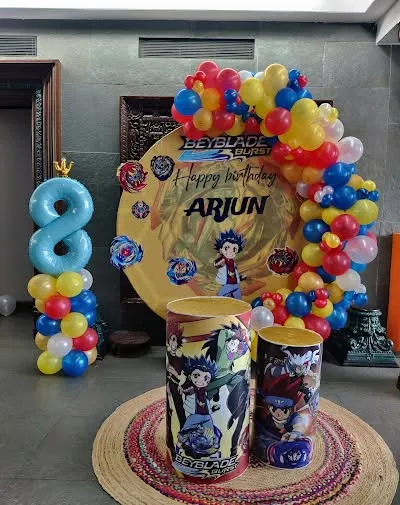 A Beyblade Burst themed birthday decoration for an 8th birthday. This colorful setup includes a themed backdrop, character-printed pedestals, and a balloon number '8'.