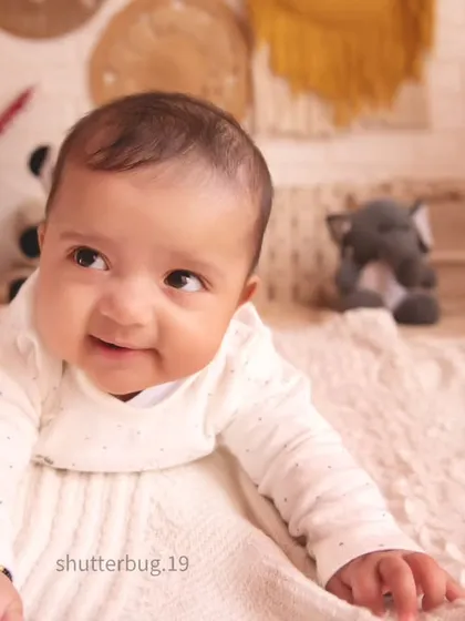 Capturing that beautiful, curious gaze. This baby is enjoying some tummy time during a family session, showing off an adorable, happy expression.