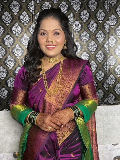 A full portrait of the bride in her purple saree.