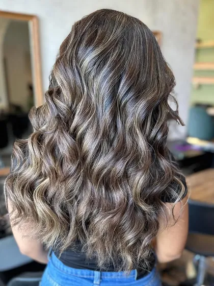 This frosty color correction took 8 hours, but the result was worth it. We transformed her hair into this cool-toned, ashy blonde with incredible dimension.