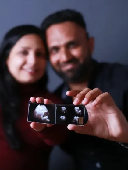 The couple proudly presents their baby's first pictures, the ultrasound scan, with the image in sharp focus, symbolizing their future.