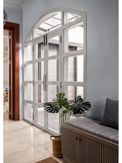 On the other side of the foyer, I added a large arched French door. It opens up the space, brings in light from the adjoining area, and creates a grand and welcoming entrance.