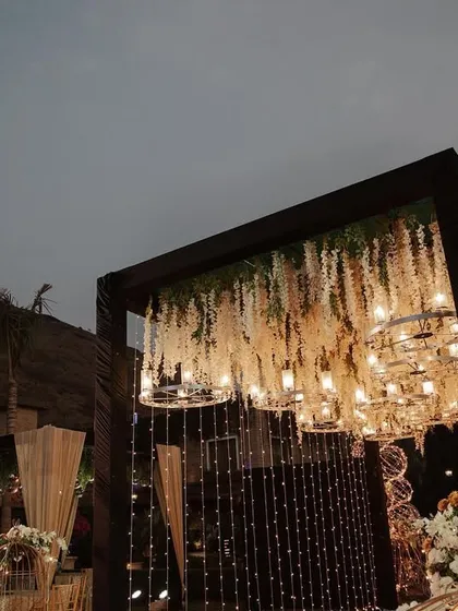 Looking up into the canopy of a grand entrance. I layered hanging wisteria, crystal chandeliers, and fairy lights to build a design that is dense, luxurious, and full of depth.