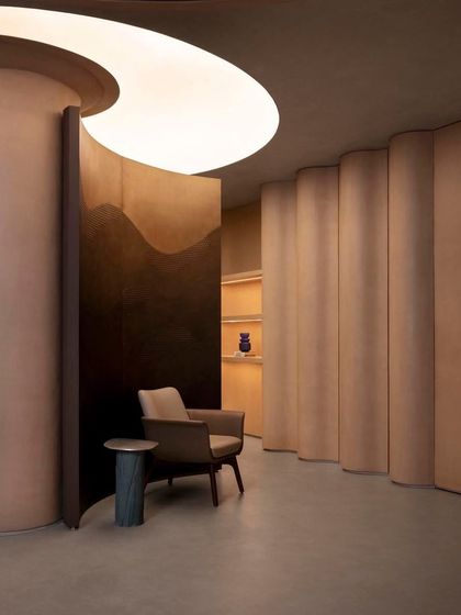 Curved partitions and carefully designed lighting create intimate nooks and moments of discovery within the open-plan showroom.