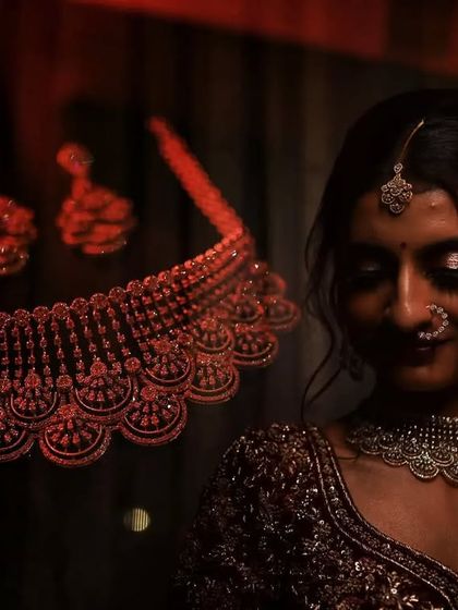 An artistic and moody shot of the bride with her necklace, using creative lighting to highlight the jewelry.