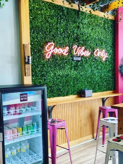 For this commercial space, we installed a simple yet eye-catching artificial green wall as a feature backdrop. The addition of a custom neon sign makes it a perfect photo opportunity for customers and enhances the cafe's vibrant atmosphere.