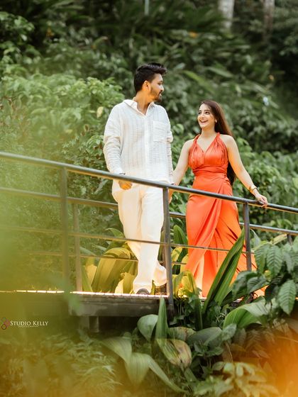 A candid moment of the couple walking hand-in-hand across a bridge in the heart of Bali's jungle. The lush green foliage creates a natural and intimate frame for the shot.