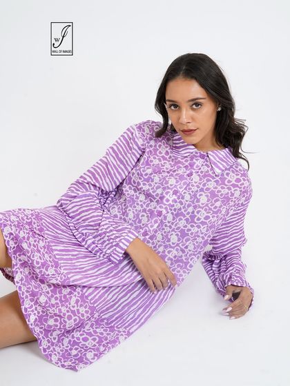 A different seated angle, providing a clear view of the dress's print and collar detail.