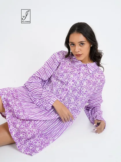 A different seated angle, providing a clear view of the dress's print and collar detail.