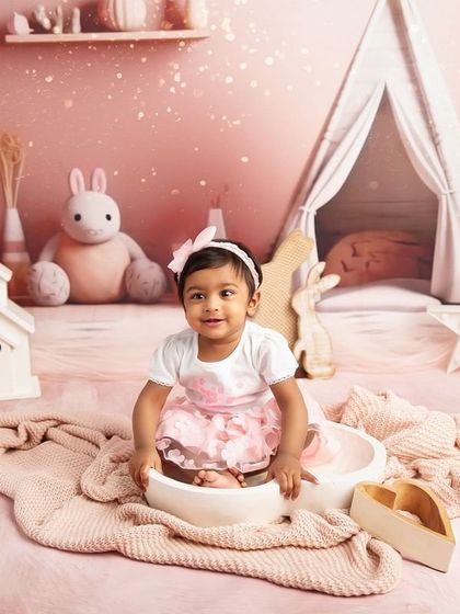A cozy moment in a bowl. This creative toddler portrait uses a simple prop to create a cute and contained shot within the larger pink-themed set.