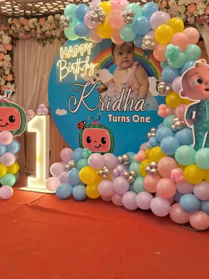 This Cocomelon theme is a favorite for first birthdays. I created a colorful setup for Kridha's first birthday with a custom backdrop featuring her photo, character cutouts, a light-up marquee number '1', and a vibrant balloon arch.