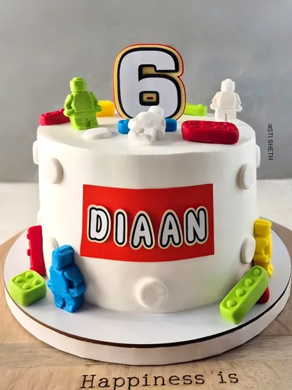 A classic Lego-themed cake for a 6th birthday. This Chocolate Mousse cake is decorated with edible Lego blocks and a personalized nameplate.