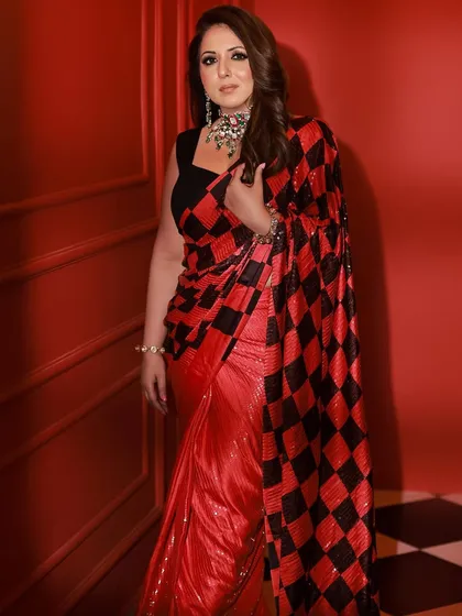 A full-length shot of the stunning sequin saree against a vibrant red background. This look is perfect for a cocktail party or a glamorous evening event.