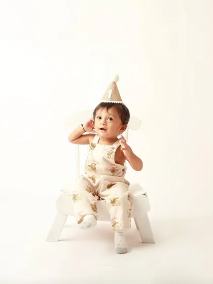 The second twin brother, just as cute, gives a curious look during his individual first birthday portrait.