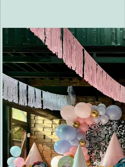 A view of the castle setup showing the mix of a silver sequin backdrop with pastel balloon arrangements.