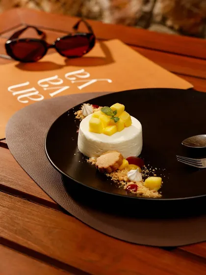 An exclusive dessert, a delicate cheesecake topped with fresh mango, showcasing the artistry of our pastry chef.