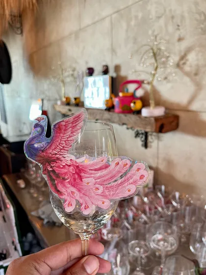 A custom-made peacock garnish clipped to a wine glass. These small, artistic details are what make our service stand out and are perfect for themed weddings or elegant parties.