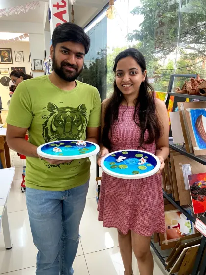 A happy couple with their finished resin koi pond art. This workshop teaches you how to create the illusion of depth and movement, making the fish look like they're swimming.