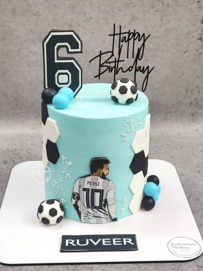 A stylish Lionel Messi cake for a 6th birthday. This light blue cake is decorated with a Messi illustration, soccer balls, and a modern hexagon pattern.