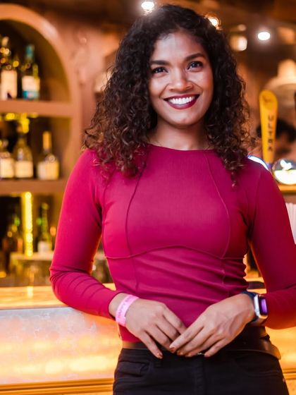 A guest with a beautiful smile, posing by the bar.
